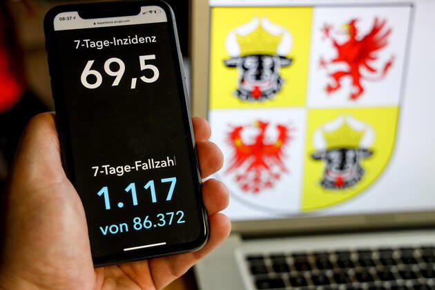 Coronavirus in Deutschland - Covid-19-Dashboard des Robert Koch-Institut DEU, Deutschland, Mecklenburg-Vorpommern, 21.03.2021: Die 7-Tage-Inzidenz für das Bundesland (Fälle letzte 7 Tage 100.000 EW) wird auf einem iPhone angezeigt, im Hintergrund das Landeswappen