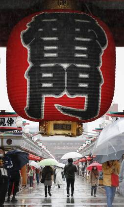 Virus emergency lifting People walk in the rain on Nakamise shopping street in Tokyo s Asakusa area on March 21, 2021, ahead of the scheduled lifting of the coronavirus state of emergency at the end of the day. 