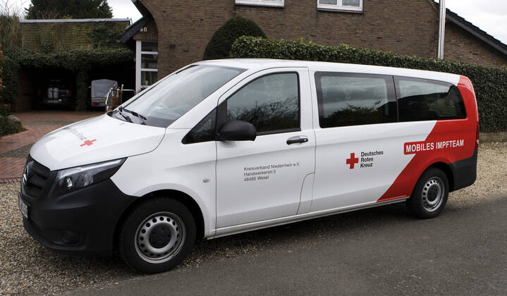 DRK Einsatzfahrzeug Mobiles Impfen Einsatzfahrzeug des DRK Wesel mit der Aufschrift Mobiles Impfteam. Das Fahrzeug wird genutzt zum Transport der Impfdosen zu den Impfzentren oder ambulanten Impforten. Das Fahrzeug steht vor einem Privathaus. Moers Deutschland Nordrhein-Westfalen NRW