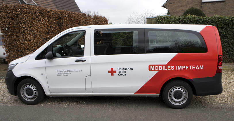 DRK Einsatzfahrzeug Mobiles Impfen Einsatzfahrzeug des DRK Wesel mit der Aufschrift Mobiles Impfteam. Das Fahrzeug wird genutzt zum Transport der Impfdosen zu den Impfzentren oder ambulanten Impforten. Das Fahrzeug steht vor einem Privathaus. Moers Deutschland Nordrhein-Westfalen NRW