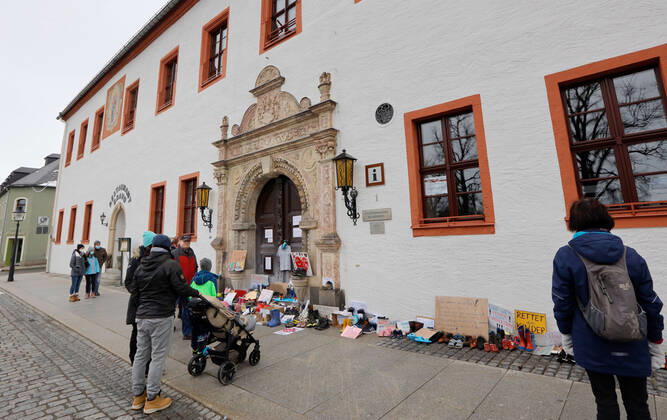 Coronaprotest_Marienberg 21.03.2021, Marienberg, Rathaus, heute Nacht brannten hier abgstellte Protestschreiben, die die Polizei schnell ablöschen konnte, Löschmittelspuren sind an der Rathaustür noch zu sehen. Auch heute Nachmittag stellen noch viele Eltern die Schuhe iherer Kinder aus Protest an die Rathaustür Chemnitz Sachsen BRD