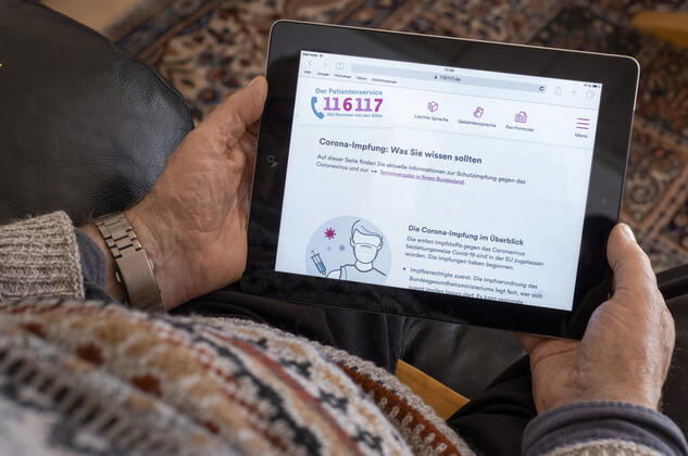 Ein aelterer Mann haelt ein iPad mit der geoeffneten Webseite des Patientenservices www.116117.de . Remscheid, 19.03.2021 Berlin Deutschland