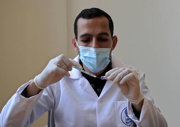 (210322) -- GAZA, March 22, 2021 -- A health worker prepares a dose of COVID-19 vaccine in Gaza City, March 22, 2021. (Photo by Xinhua) MIDEAST-GAZA CITY-COVID-19-VACCINATION RizekxAbdeljawad 