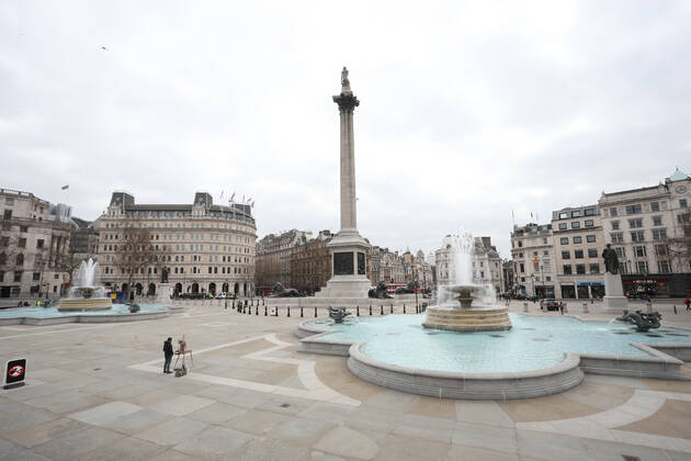 An artist stops working during the moment of reflection in Trafalgar Square. Today marks the first anniversary of the start of UK lockdown restrictions because of the COVID-19 Coronavirus pandemic. A national minute s silence at 12.00pm marks the moment of reflection. London is pictured today (March 23, 2021), on the anniversary of the first Coronavirus lockdown. 