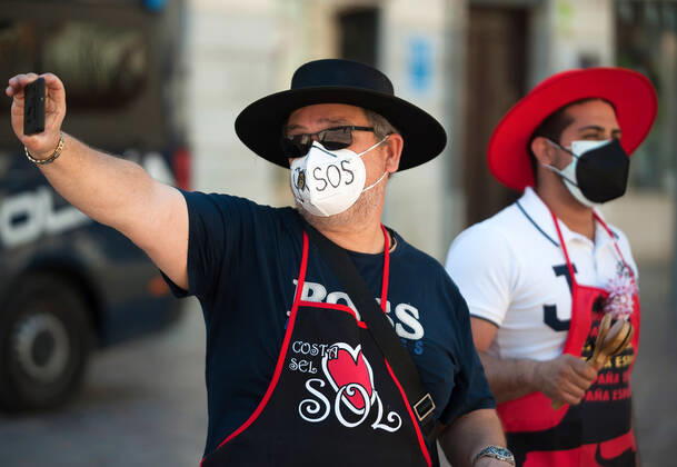 March 23, 2021, Malaga, Spain: A protester wearing a mask takes a selfie at Plaza de la Constitucion square during the demonstration..Employees from S.O.S Souvenirs association in Malaga, who work in tourists stores of souvenirs, demand the Spanish government sector survival facing fall incomes due to coronavirus pandemic. Many tourist stores and shops have had to close after restrictions of tourist sector and arrivals of tourists in Spain. Malaga Spain - ZUMAs197 20210323_zaa_s197_001 Copyright: xJesusxMeridax