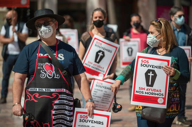 March 23, 2021, Malaga, Spain: Protesters wearing masks hold placards at Plaza de la Constitucion square during the demonstration..Employees from S.O.S Souvenirs association in Malaga, who work in tourists stores of souvenirs, demand the Spanish government sector survival facing fall incomes due to coronavirus pandemic. Many tourist stores and shops have had to close after restrictions of tourist sector and arrivals of tourists in Spain. Malaga Spain - ZUMAs197 20210323_zaa_s197_006 Copyright: xJesusxMeridax