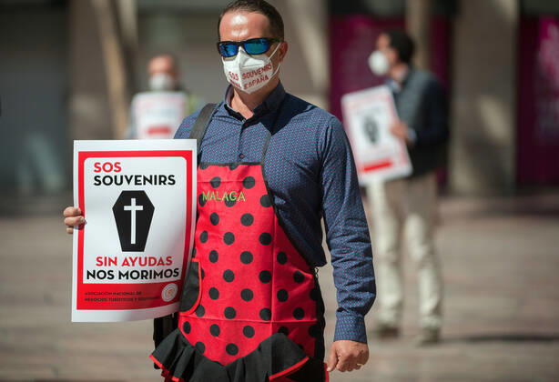 March 23, 2021, Malaga, Spain: A protester wearing a mask holds a placard at Plaza de la Constitucion square during the demonstration..Employees from S.O.S Souvenirs association in Malaga, who work in tourists stores of souvenirs, demand the Spanish government sector survival facing fall incomes due to coronavirus pandemic. Many tourist stores and shops have had to close after restrictions of tourist sector and arrivals of tourists in Spain. Malaga Spain - ZUMAs197 20210323_zaa_s197_008 Copyright: xJesusxMeridax