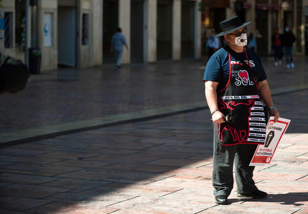 March 23, 2021, Malaga, Spain: A protester wearing a mask holds a placard at Plaza de la Constitucion square during the demonstration..Employees from S.O.S Souvenirs association in Malaga, who work in tourists stores of souvenirs, demand the Spanish government sector survival facing fall incomes due to coronavirus pandemic. Many tourist stores and shops have had to close after restrictions of tourist sector and arrivals of tourists in Spain. Malaga Spain - ZUMAs197 20210323_zaa_s197_012 Copyright: xJesusxMeridax