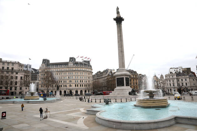 An artist stops painting and a few people pause during the moment of reflection in a very quiet Trafalgar Square. Today marks the first anniversary of the start of UK lockdown restrictions because of the COVID-19 Coronavirus pandemic. A national minute s silence at 12.00pm marks the moment of reflection. London is pictured today (March 23, 2021), on the anniversary of the first Coronavirus lockdown. 