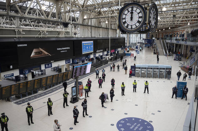 (210324) -- LONDON, March 24, 2021 -- Travellers, police officers and rail staff observe one minute s silence at Waterloo Station in London, Britain, on March 23, 2021. Britain on Tuesday marked one year since British Prime Minister Boris Johnson announced the first coronavirus lockdown in the country last year. On March 23, 2020, Johnson unveiled measures to stop the spread of COVID-19. A national minute s silence was held at midday as part of a day of reflection. Britons are also encouraged to stand on their doorsteps at 2000 GMT with phones, candles and torches to remember the past year. (Photo by Xinhua) BRITAIN-LONDON-COVID-19-NATIONAL DAY OF REFLECTION RayxTang 