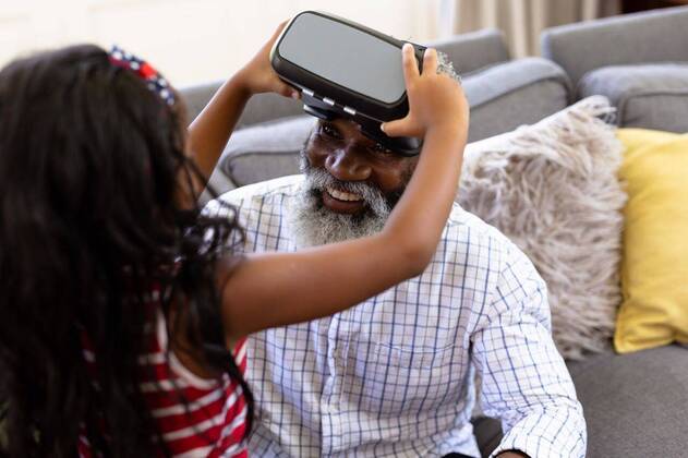 Senior African American man and his granddaughter Using vr headset Senior African American man and his granddaughter enjoying their time at home together, sitting on a couch, wearing a VR headset, model released, , property released, Cape Town, South Africa, 19.02.2020, 1340098.jpg, people,family,grandfather,granddad,granddaughter,childhood,together,closeness,interacting,sitting,couch,happy,smiling,wearing,using,vr,virtual reality,headset,connection,communication,real people,home,house,domestic life,lifestyle,enjoying,free time,leisure,relaxing,weekend,summer,sunny,love Child,Girl,Female,Mixed-Race,Mid Adult,Man,Male,Black Indoors,Front view,Looking at camera,Day,Half length