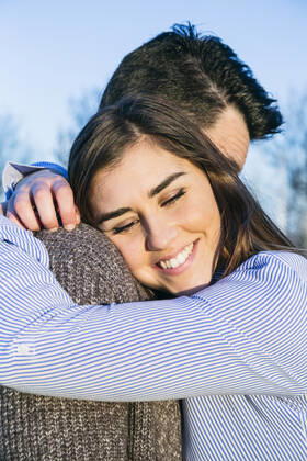 Smiling girlfriend embracing boyfriend during sunset model released Symbolfoto ABZF03506
