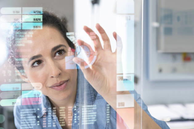 IMAGO Creative, Internationaler Frauenmonat, Entrepreneurinnen Female entrepreneur touching projection glass screen in factory model released Symbolfoto property released FKF04093
