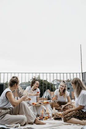 IMAGO Creative: Jahreszeit Frühling, Picknick Friends enjoying adundant picnich on rooftop trerrace model released Symbolfoto property released LHPF01411