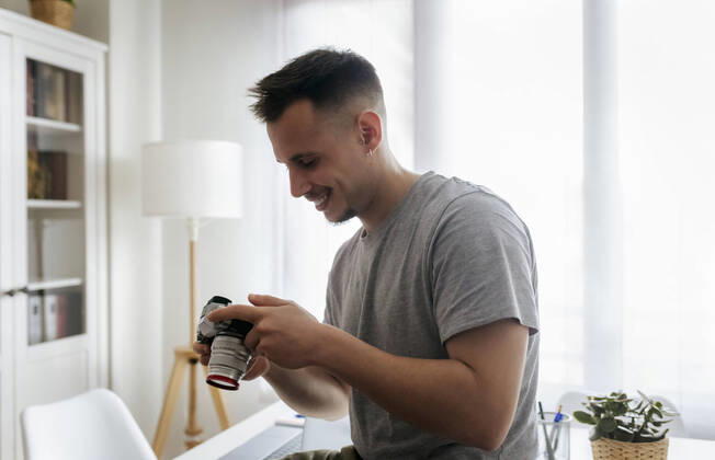 IMAGO Creative: Kreative Renaissance -- der junge Entrepreneur Smiling male entrepreneur holding camera at home office model released Symbolfoto property released MGOF04689