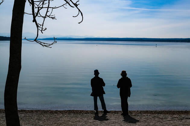 Frühlingswetter am Ammersee 25.03.2021: Ausflügler bei Frühlingswetter am Ufer des Ammersees bei Stegen (Inning am Ammersee; Oberbayern) mit Blick in Richtung Alpen. Inning Bayern Deutschland