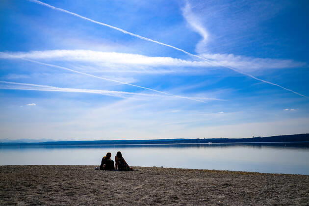 Frühlingswetter am Ammersee 25.03.2021: Ausflügler bei Frühlingswetter am Ufer des Ammersees bei Stegen (Inning am Ammersee; Oberbayern) mit Blick in Richtung Alpen. Inning Bayern Deutschland