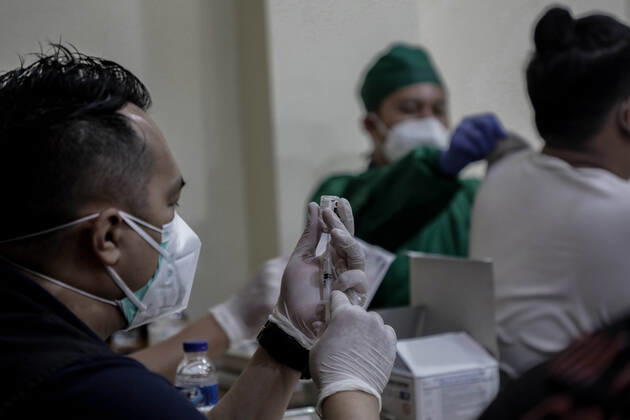 March 25, 2021, Depok, Jawa Barat, Indonesia: A healthcare worker preparing a dose of Sinovac COVID-19 vaccine during a mass vaccination drive for the public sector workers at Geospatial Information Agency Office in Bogor..Indonesia is currently in the second phase of mass covid-19 vaccination. In this second phase, the Indonesian government targets 38.5 million people, including 16.9 million workers in public sectors and 21.6 million elderly citizens, as well as workers in hospitality, transportation, tourism sectors and mass media workers. Depok Indonesia - ZUMAs197 20210325_zaa_s197_087 Copyright: xRisaxKrisadhix
