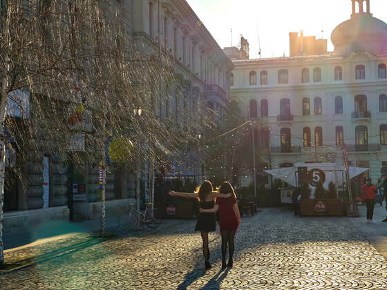 Two girls dancing in the Old town with restaurants and bars with tourists and local people in Bucharest, Romania on March 27, 2021.