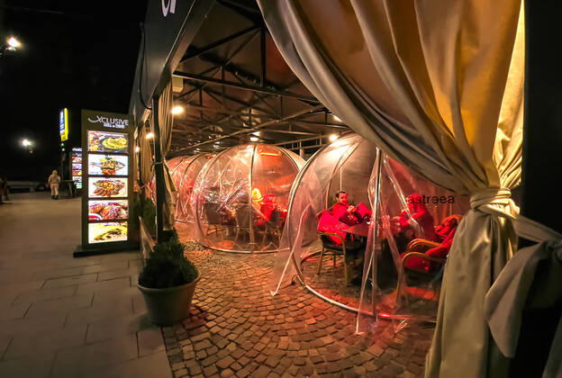 Corona bubbles, protective covers made of plastic in the Old town with restaurants and bars with tourists and local people in Bucharest, Romania on March 27, 2021.
