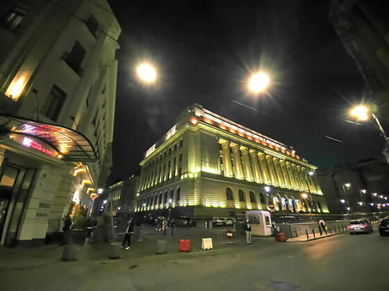 Old town with restaurants and bars with tourists, National Bank of Romania and local people in Bucharest, Romania on March 27, 2021.