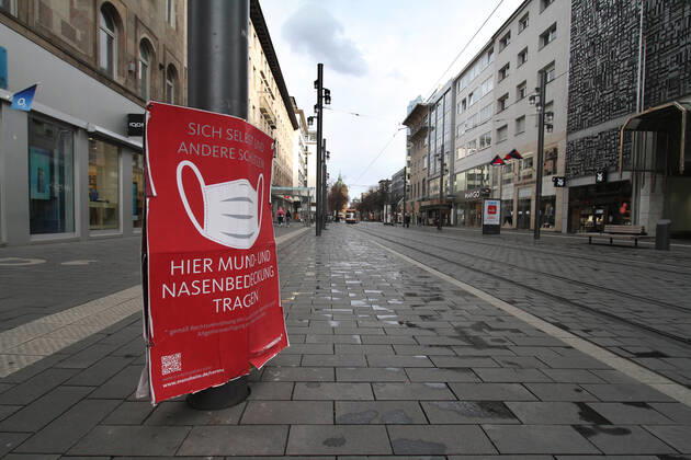 Ein Schild mit Piktogramm und Aufschrift Maskenpflicht hängt in der weitgehend menschenleeren Fußgängerzone und Einkaufsstraße Planken in der Innenstadt von Mannheim, Baden Württemberg, Deutschland
