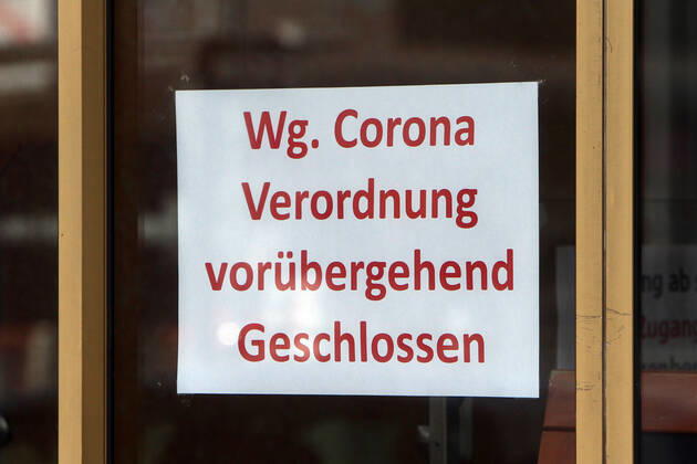 Schild mit Aufschrift wegen Corona Verordnung vorübergend geschlossen hängt an der Eingangstür eines geschlossenen Geschäfts in der Innenstadt von Mannheim, Baden Württemberg, Deutschland