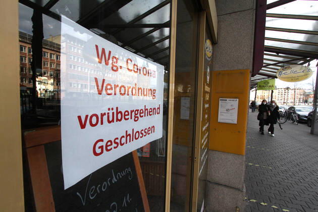 Schild mit Aufschrift wegen Corona Verordnung vorübergend geschlossen hängt an der Eingangstür eines geschlossenen Geschäfts in der Innenstadt von Mannheim, Baden Württemberg, Deutschland