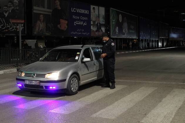 (210328) -- GAZA, March 28, 2021 -- A Palestinian police officer checks a car in Gaza City, March 27, 2021. The Hamas-run Interior Ministry imposed a full lockdown on Saturday all over the Gaza Strip at night-time from 9:00 PM due to increasing numbers of COVID-19 infection. (Photo by Xinhua) MIDEAST-GAZA CITY-COVID-19 RizekxAbdeljawad 