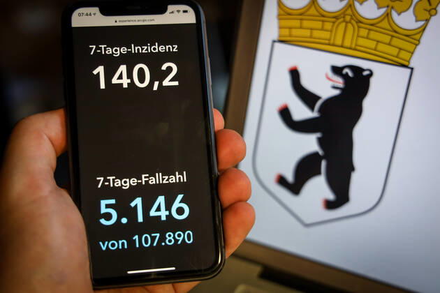 Coronavirus in Deutschland - Covid-19-Dashboard des Robert Koch-Institut DEU, Deutschland, Berlin, 28.03.2021: Die 7-Tage-Inzidenz für das Bundesland (Fälle letzte 7 Tage 100.000 EW) wird auf einem iPhone angezeigt, im Hintergrund das Landeswappen