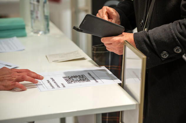 29.03.2021 Weimar: Eine Mitarbeiterin ist älteren Menschen behilflich beim Einchecken mithilfe der Luca App, in einem Geschäft der Konsumgenossenschaft Weimar. Weimar öffnet als erste Stadt in Thüringen vom 29. bis 31. März testweise alle Geschäfte der Innenstadt für Einkäufe - Bedingung ist ein aktueller negativer Corona Schnelltest.
