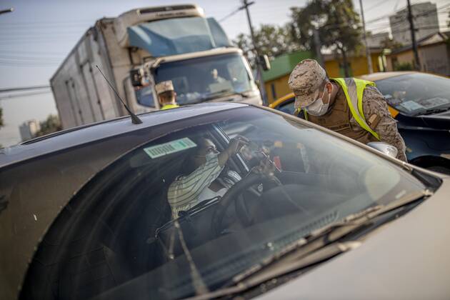 March 29, 2021, Santiago, Chile: A man shows his health permit to a policeman at a health checkpoint..Sanitary cords and police controls during the first day of total quarantine in the central area of the country, after the abrupt increase in Covid-19 cases in the Metropolitan region, the country s health authorities decreed a total quarantine for the central area of the country. Although Chile leads the number of vaccinated population, the increase in positive cases puts the stability of the health system at risk again. Santiago Chile - ZUMAs197 20210329_zaa_s197_153 Copyright: xFelipexFigueroax