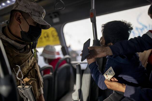 March 29, 2021, Santiago, Chile: A Bolivian migrant shows his health permit to a policeman during a public transport inspection..Sanitary cords and police controls during the first day of total quarantine in the central area of the country, after the abrupt increase in Covid-19 cases in the Metropolitan region, the country s health authorities decreed a total quarantine for the central area of the country. Although Chile leads the number of vaccinated population, the increase in positive cases puts the stability of the health system at risk again. Santiago Chile - ZUMAs197 20210329_zaa_s197_157 Copyright: xFelipexFigueroax