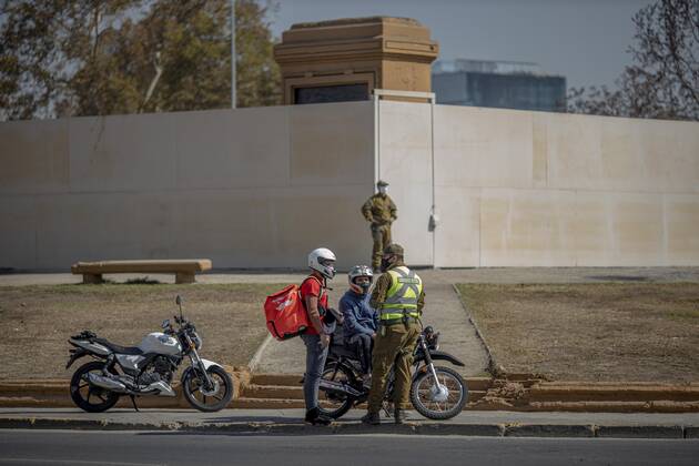 March 29, 2021, Santiago, Chile: Police officer verifies health permits for delivery drivers at a health checkpoint in Santiago..Sanitary cords and police controls during the first day of total quarantine in the central area of the country, after the abrupt increase in Covid-19 cases in the Metropolitan region, the country s health authorities decreed a total quarantine for the central area of the country. Although Chile leads the number of vaccinated population, the increase in positive cases puts the stability of the health system at risk again. Santiago Chile - ZUMAs197 20210329_zaa_s197_165 Copyright: xFelipexFigueroax