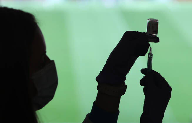 A health professional holds a syringe and a vial with the Covid-19 vaccine, in a device installed at the Wanda Metropolitano Stadium, in Madrid, Spain, on March 30, 2021. The Community of Madrid has begun to vaccinate this Tuesday against Covid-19 to the general population aged 60 to 65 years with doses of AstraZeneca. Also, next week will begin to vaccinate people aged 77, 78 and 79 years with doses of Pfizer. 30 MARCH 2021;WANDA METROPOLITANO;MADRID;COMMUNITY OF MADRID Marta Fernandez Jara LagenciaEP 03 30 2021 MADRID MADRID Spain Copyright: xMartaxFernandezxJarax 3627704