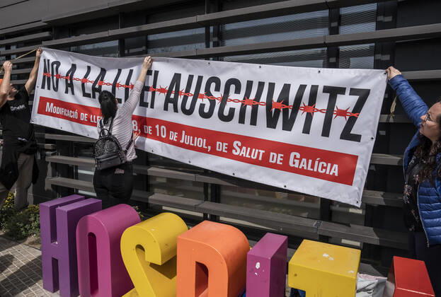 March 31, 2021, Barcelona, Catalonia, Spain: Protesters hang up a banner against Law 8 2008 approved by the Galician Parliament regulating health rights and obligations known as the Auschwitz Law during the demonstration..Summoned by the platform against the obligation of sanitary masks in minors, El Tercer Grupo, some fifty people have gathered at the doors of the Sant Joan De Deu Children s Hospital to protest the call of the hospital to carry out tests of the covid 19 vaccine on minors. Barcelona Spain - ZUMAs197 20210331_zaa_s197_053 Copyright: xPacoxFreirex