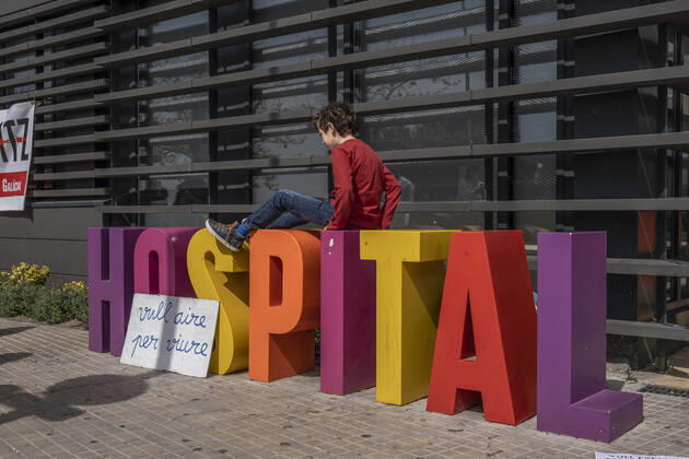 March 31, 2021, Barcelona, Catalonia, Spain: A minor playing on the hospital sign next to a placard saying I want air to live during the demonstration..Summoned by the platform against the obligation of sanitary masks in minors, El Tercer Grupo, some fifty people have gathered at the doors of the Sant Joan De Deu Children s Hospital to protest the call of the hospital to carry out tests of the covid 19 vaccine on minors. Barcelona Spain - ZUMAs197 20210331_zaa_s197_059 Copyright: xPacoxFreirex