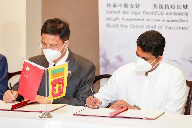 (210401) -- COLOMBO, April 1, 2021 -- China s Ambassador to Sri Lanka Qi Zhenhong (L) and Sri Lanka s State Minister of Pharmaceutical Production, Supply and Regulation Channa Jayasumana attend an official certificate signing ceremony at the Bandaranaike International Airport in Colombo, Sri Lanka, March 31, 2021. A batch of Sinopharm vaccines arrived in Sri Lanka from China on Wednesday as part of a donation by the Chinese government to the island nation. ( Handout via Xinhua) SRI LANKA-COLOMBO-CHINA-COVID-19-VACCINES-ARRIVAL SrixLankanxPresidentxMediaxDivision 
