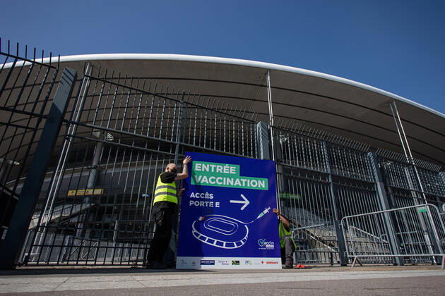 Coronavirus in Frankreich, neues Impfzentrum im Stade de France in Paris (210331) -- SAINT-DENIS (FRANCE), March 31, 2021 -- Staff members set up a sign of a new COVID-19 vaccination center in Saint-Denis, France, on March 31, 2021. Starting from mid-April people over 60 in France will be able to get vaccinated, from May 15 the vaccination will be open to people aged between 50 and 60 and from mid-June the age limit will be lifted, said French President Emmanuel Macron on Wednesday. (Photo by Xinhua) FRANCE-SAINT-DENIS-VACCINATION CENTER AurelienxMorissard 