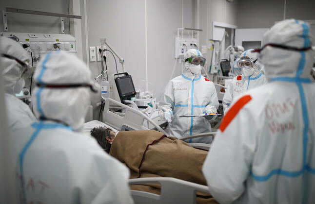 MOSCOW, RUSSIA - APRIL 1, 2021: Medical workers treat a patient at a temporary COVID-19 hospital at the Sokolniki Exhibition and Convention Center. The treatment facility has a reserve hospital and an observation center; its capacity is 550 beds, including 18 for intensive therapy patients. Sergei Bobylev TASS  TS0FB394