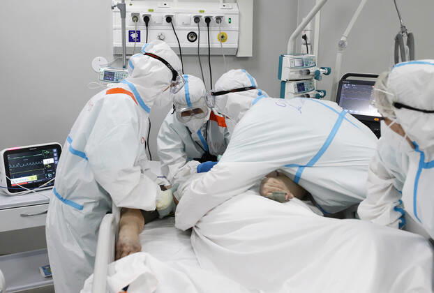 MOSCOW, RUSSIA - APRIL 1, 2021: Medical workers treat a patient at a unit of a temporary COVID-19 hospital at the Sokolniki Exhibition and Convention Center. The treatment facility has a reserve hospital and an observation center; its capacity is 550 beds, including 18 for intensive therapy patients. Sergei Bobylev TASS  TS0FB3BA