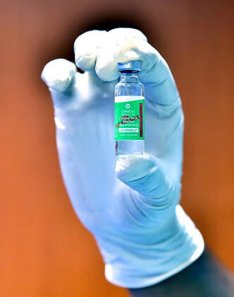 (210401) -- BANGALORE, April 1, 2021 -- A health worker displays a vial of the COVID-19 vaccine at a hospital in Bangalore, India, April 1, 2021. The third phase of vaccination to curb the COVID-19 pandemic began in India on Thursday, during which all people aged above 45 years would be given vaccine jabs. (Str Xinhua) INDIA-BANGALORE-COVID-19-VACCINATION Stringer 