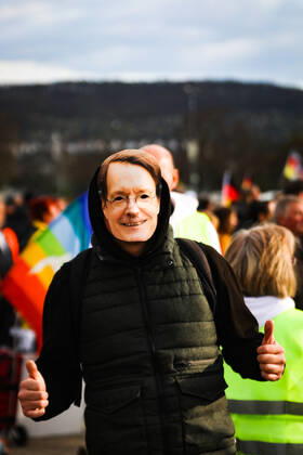 Demonstration gegen Corona Auflagen in Stuttgart 03.04.2021 Stuttgart Teilnehmer bei einer Kundgebung gegen die Corona Auflagen auf dem Cannstatter Wasen in Stuttgart. Ein Teilnehmer trägt eine Maske mit dem Konterfei von Karl Lauterbach. Kassel Hessen Deutschland