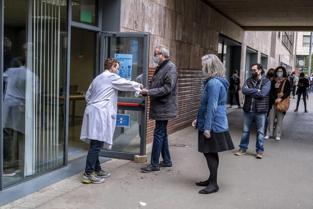 April 4, 2021, Barcelona, Spain: A health worker is seen at the vaccination point of the Faculty of Geography and History disinfecting the hands of people who enter to be vaccinated with the AstraZeneca vaccine..Queues in Barcelona to get vaccinated against Covid-19 during the Holy Week at the vaccination point of the Faculty of Geography and History. Barcelona Spain - ZUMAs197 20210404_zaa_s197_011 Copyright: xPacoxFreirex
