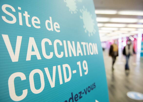 April 4, 2021, Montreal, PQ, Canada: People walk by a sign for a COVID-19 vaccination site in Montreal, Sunday, April 4, 2021. Montreal Canada - ZUMAc35_ 20210404_zaf_c35_016 Copyright: xGrahamxHughesx