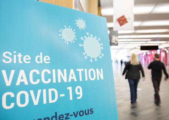 April 4, 2021, Montreal, PQ, Canada: People walk by a sign for a COVID-19 vaccination site in Montreal, Sunday, April 4, 2021. Montreal Canada - ZUMAc35_ 20210404_zaf_c35_017 Copyright: xGrahamxHughesx