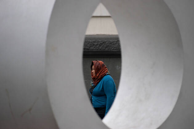 April 4, 2021, Santiago, Metropolitana, Chile: A woman with a mask passes in front of the O of a giant sign that says STGO, in the middle of the total quarantine decreed last week for the Metropolitan Region. Santiago Chile - ZUMAb332 20210404_zip_b332_016 Copyright: xMatiasxBasualdox