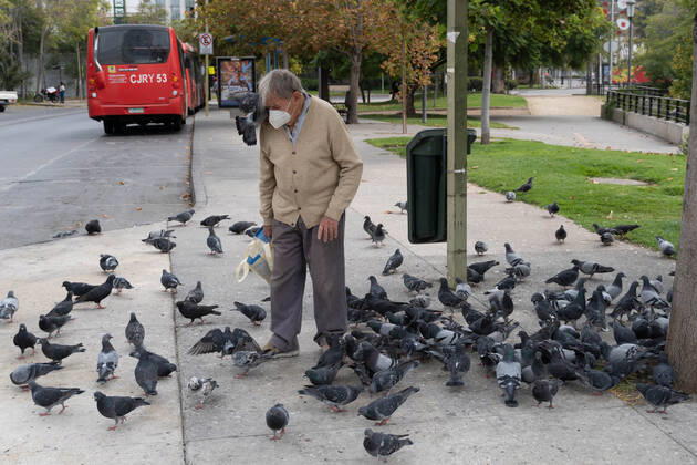 April 4, 2021, Santiago, Metropolitana, Chile: A man with a mask feeds pigeons, amid the total quarantine decreed last week for the Metropolitan Region. Santiago Chile - ZUMAb332 20210404_zip_b332_035 Copyright: xMatiasxBasualdox