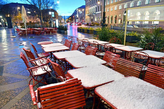 Themenbild: Coronavirus Pandemie Folgen fuer die Gastronomie-kommt nun der Bruecken Lockdown? Schneebedckte und zusammengebundene leere Tische und Stuehle vor einem Restaurant,Aussengastronomie in der Brienner Strasse in Muenchen am 06.04.2021 nach Wintereinbruch.