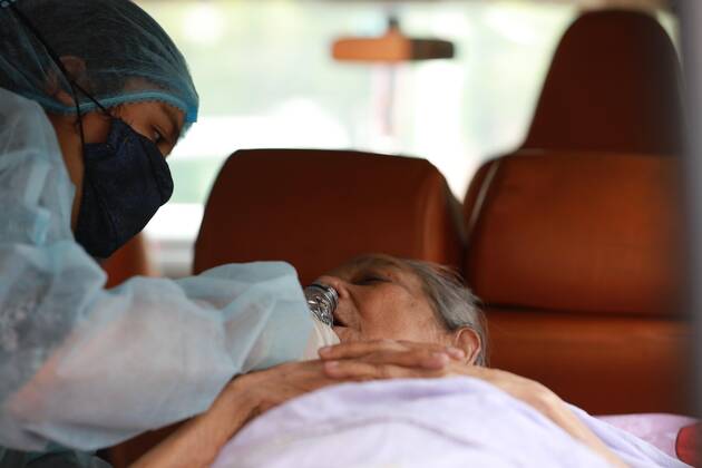 April 9, 2021, Dhaka, Dhaka, Bangladesh: April, 09,2021 A relative of a woman who has infected by the COVID-19 and she wearing a protective suit help to drink water to elderly woman in an ambulance, Dhaka, Bangladesh Dhaka Bangladesh - ZUMAr338 20210409_zip_r338_016 Copyright: xHarun-Or-Rashidx